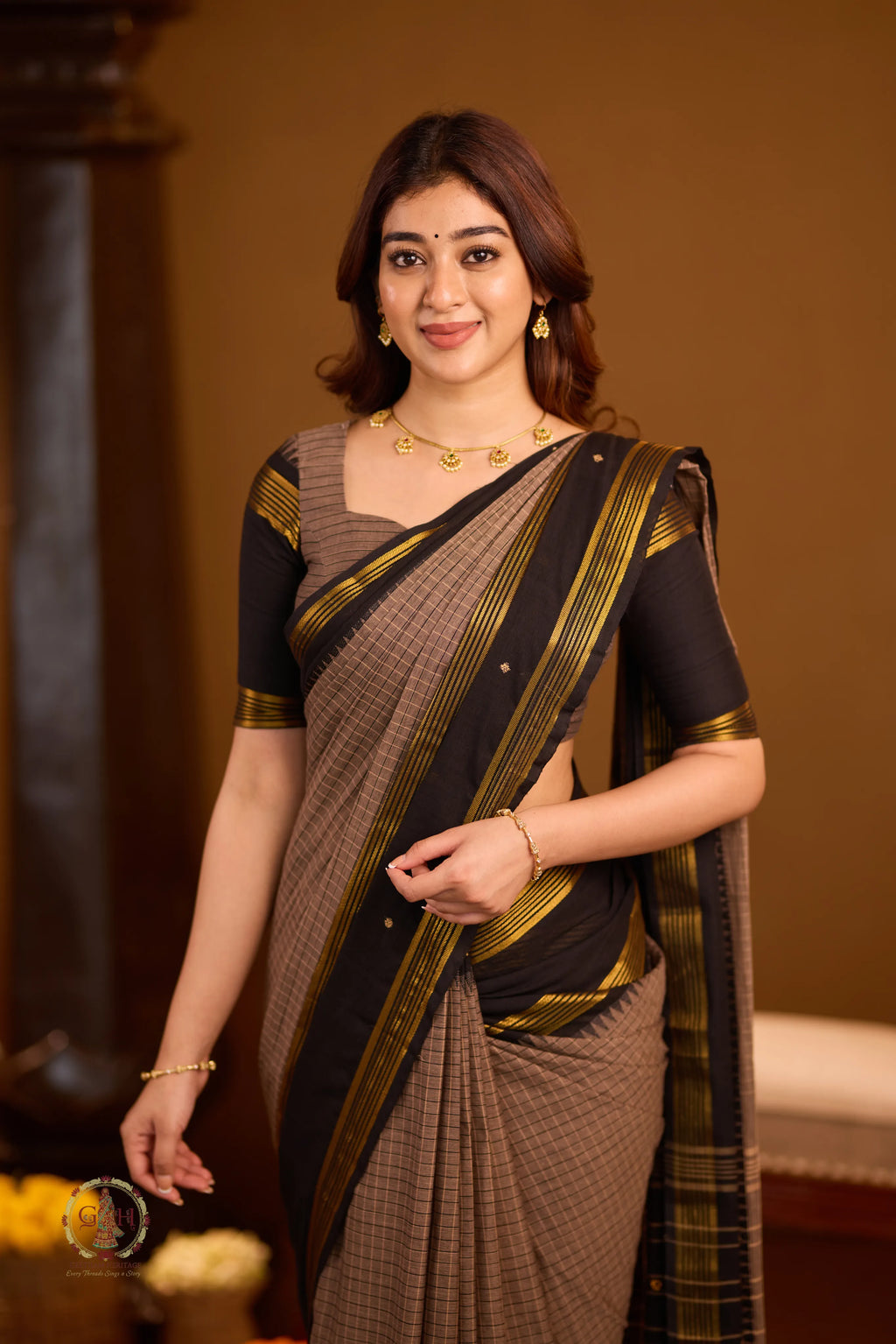Warm brown with black border and golden zari detailing