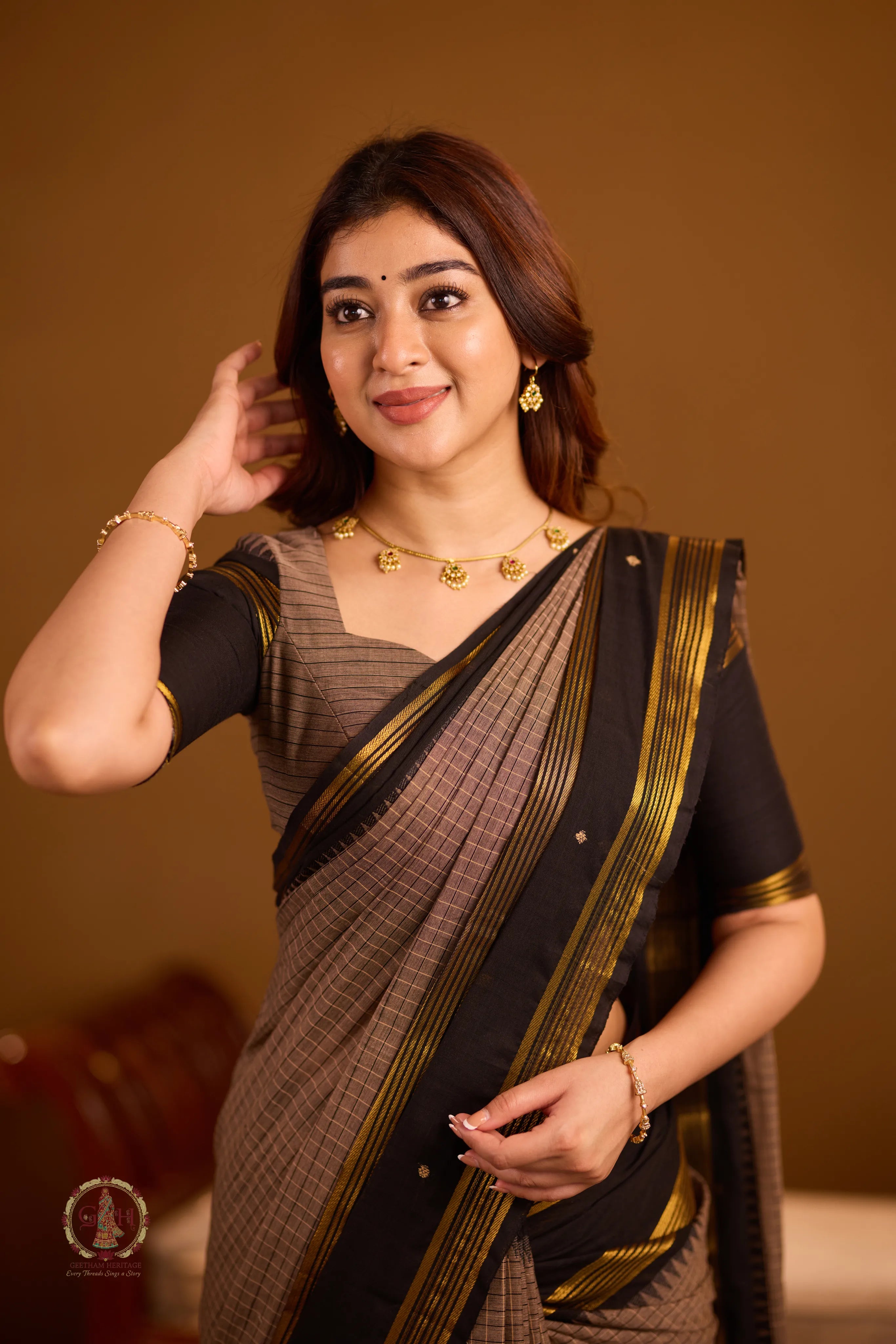 Warm brown with black border and golden zari detailing
